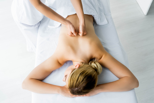 recortado vista de masajista haciendo masaje de espalda a mujer en spa
  - Foto, Imagen