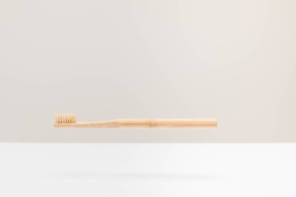 dřevěný zubní kartáček nad bílou plochou izolovaný na šedé - Fotografie, Obrázek