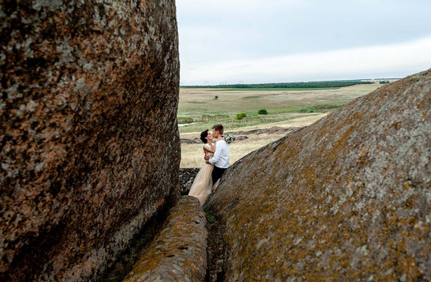 pareja de novios abrazándose cerca de las rocas
 - Foto, Imagen