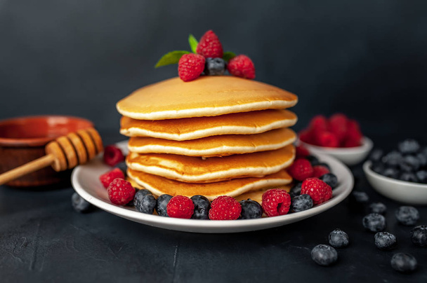 homemade pancakes with honey, raspberries and blueberries - Photo, image