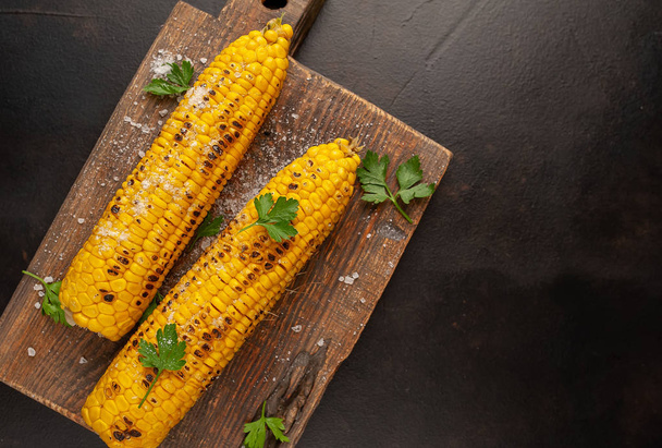 fresh organic corn with salt on a wooden board - Photo, Image