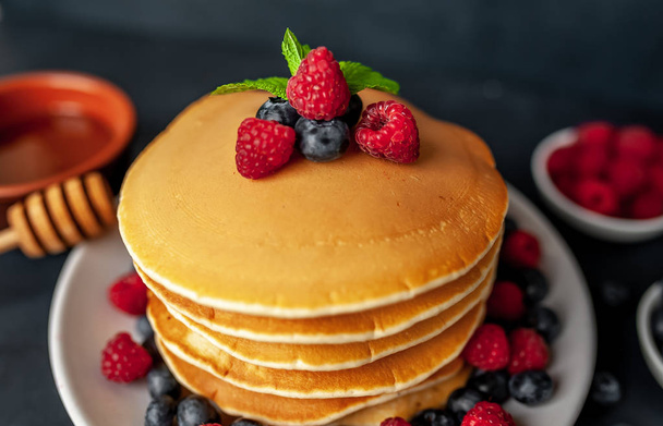 homemade pancakes with honey, raspberries and blueberries - Фото, зображення