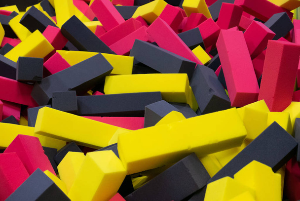 Piscina nel centro giochi per bambini riempito da cubi gialli rossi e neri
 - Foto, immagini