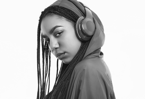Αφρικανικό έφηβο κορίτσι με ντρέφι σε κόκκινο αντιανεμικό ακούνε - Φωτογραφία, εικόνα
