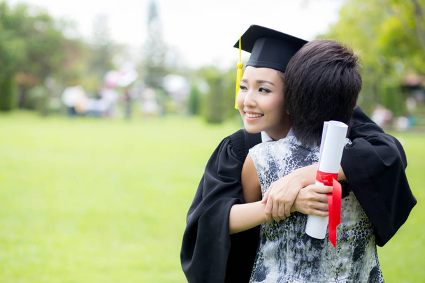 młody absolwent kobiece przytulanie jej przyjaciel w ceremonii ukończenia szkoły - Zdjęcie, obraz