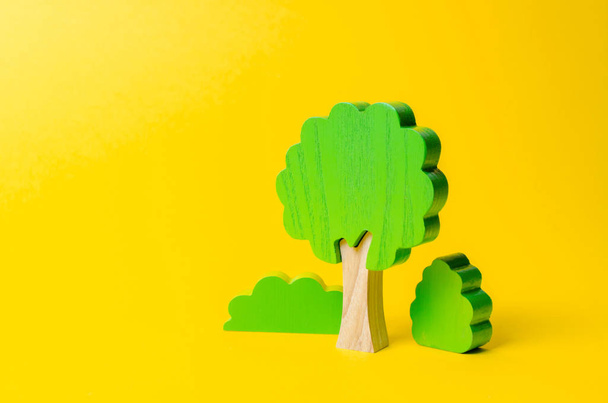 Wooden figures of trees and bushes on an orange background. Preserving the environment from human influence. Illegal deforestation. Restoration of natural habitats The concept of forests and nature. - Photo, image