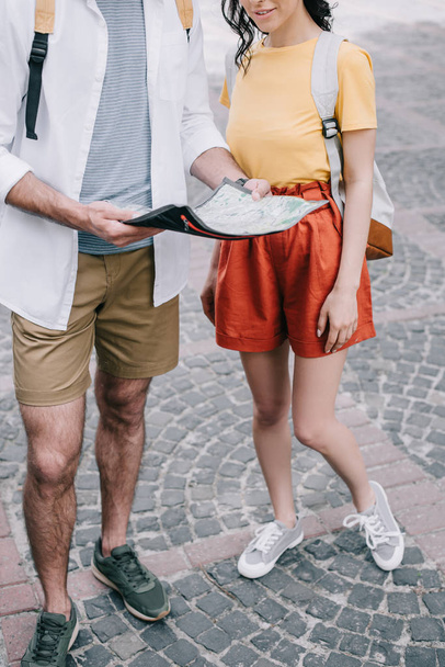 cropped view of girl standing with man holding map  - Foto, immagini