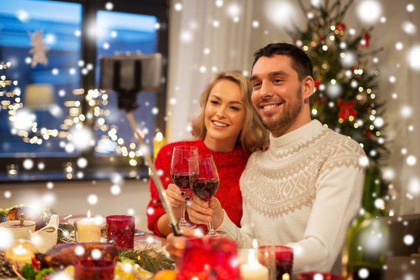 couple taking picture by selfie stick at christmas - Fotografie, Obrázek