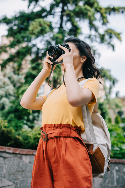  low angle view of girl holding digital camera while taking photo  - Φωτογραφία, εικόνα
