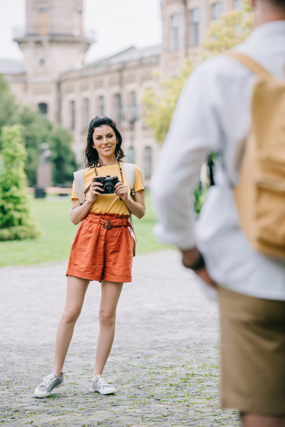 selective focus of woman standing near university with digital camera - Zdjęcie, obraz