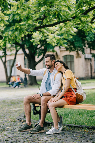 happy man taking selfie with cheerful young woman on smartphone - Фото, зображення
