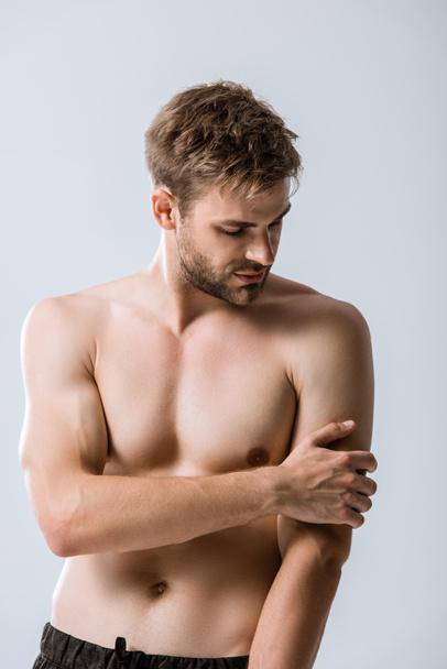 shirtless muscular man with pain in arm isolated on grey - Fotó, kép