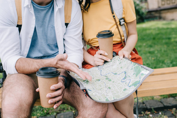 cropped view of man and woman holding paper cups and map  - Photo, Image