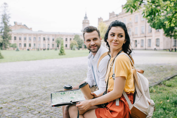 happy woman and man holding paper cups and map - Фото, изображение