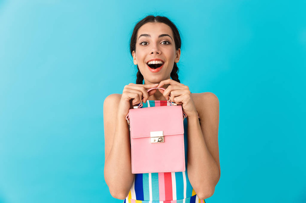 Image of pleased delighted woman with pigtails holding pink bag and smiling - Foto, Imagen