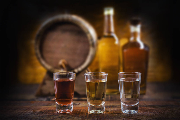 alcoholic beverages, cachaca, drips, rum and brandy. Selection of strong and hard alcoholic drinks, glasses. Vodka, brandy, tequila, brandy and whiskey, grappa, liqueur, vermouth, tincture, rum. - Photo, Image