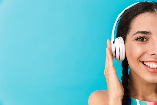 Cropped image of brunette happy woman smiling while using headphones - 写真・画像