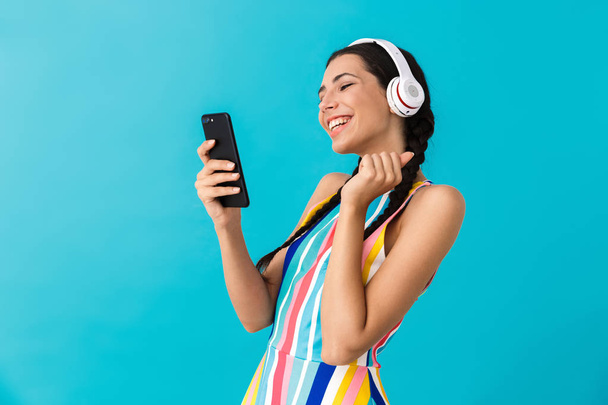 Image of nice happy woman with pigtails using headphones and making video call on cellphone - Foto, immagini