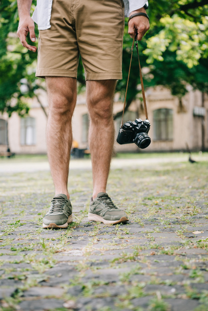 περικομμένη όψη του ανθρώπου που στέκεται με ψηφιακή κάμερα έξω  - Φωτογραφία, εικόνα