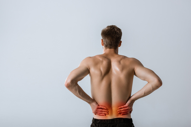 back view of shirtless sportsman with lower back pain isolated on grey - Fotoğraf, Görsel