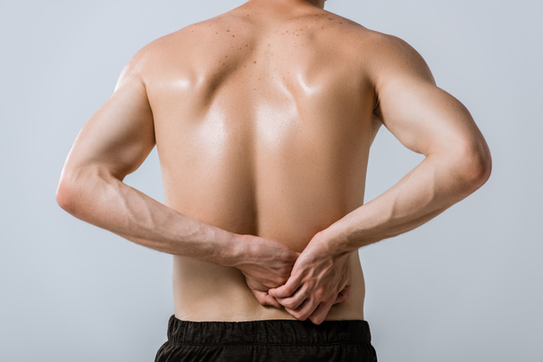 back view of shirtless sportsman with lower back pain isolated on grey - Fotoğraf, Görsel