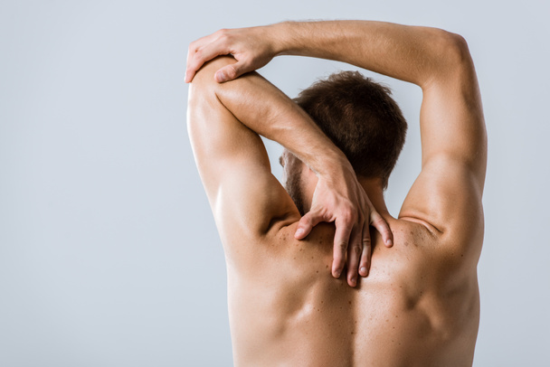 back view of shirtless sportsman stretching isolated on grey - Fotoğraf, Görsel