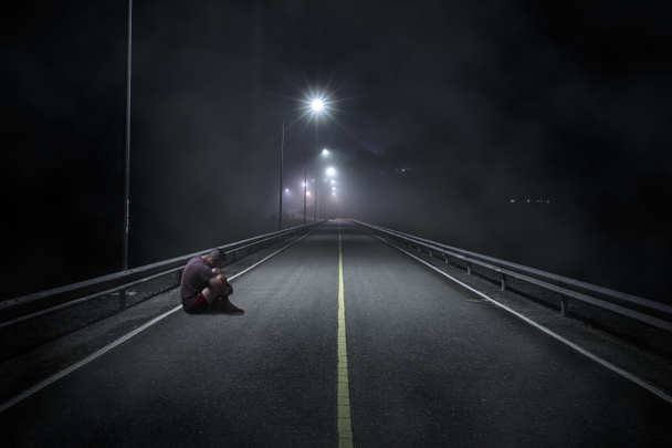 Adolescente problemático com o rosto escondido sentado na rua da noite
 - Foto, Imagem