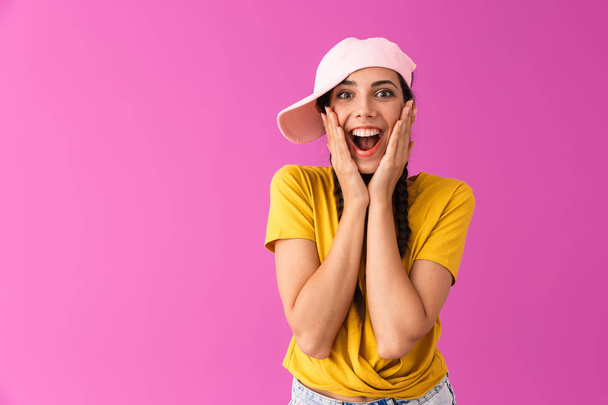 Photo of excited joyful woman wearing cap smiling and touching her cheeks - 写真・画像