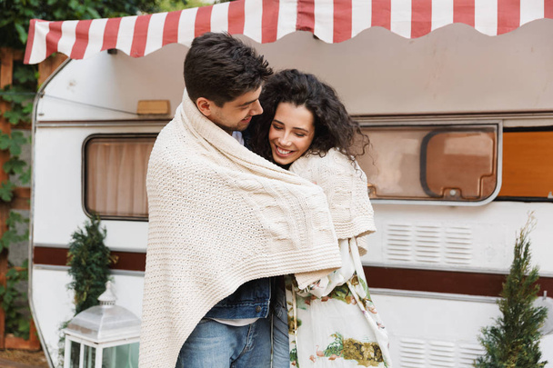 Romantic cute positive loving couple man and woman hugging near trailer mobile home in plaid. - Fotoğraf, Görsel