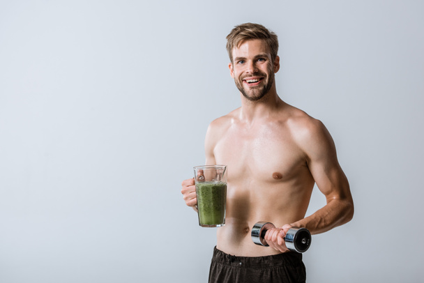 shirtless sportsman holding smoothie and dumbbell isolated on grey - Φωτογραφία, εικόνα