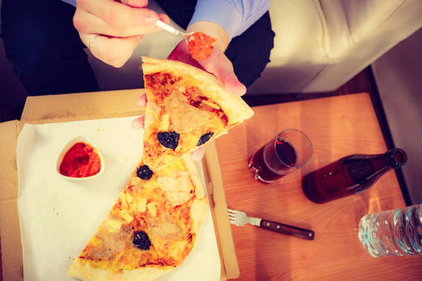 Man eating pizza adding tomato sauce - Foto, immagini