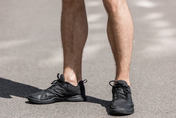 cropped view of sportsman in black sneakers on street - 写真・画像