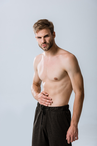 deportista sin camisa con dolor abdominal aislado en gris
 - Foto, Imagen