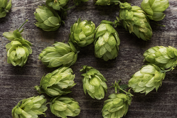 top view of fresh green hop on wooden surface - Foto, Imagen