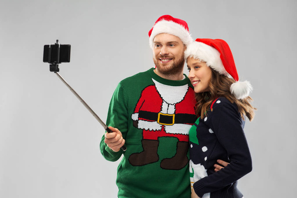 happy couple in christmas sweaters taking selfie - Photo, Image