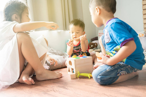 Asian cute little children playing with toy box while sitting on - Photo, Image
