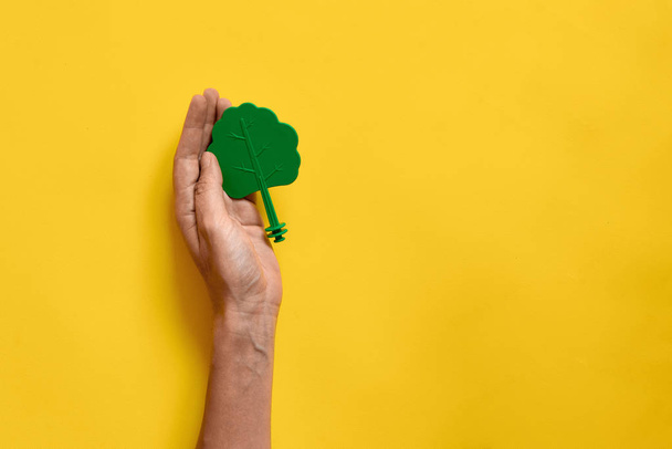 Plastic toy wood tree on yellow background. Minimal flat lay of ecology environment - Foto, imagen