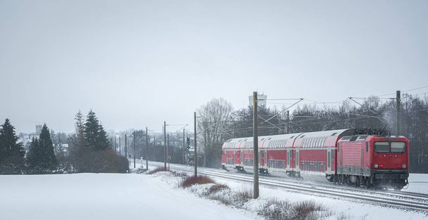 Matkustajat harjoittelevat talvimaisemassa. Juna lumisella radalla
 - Valokuva, kuva