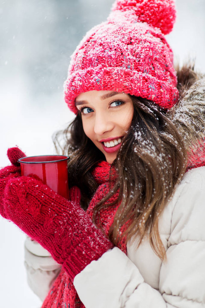 happy young woman with tea cup in winter park - Foto, afbeelding