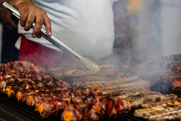 Chef préparant la viande sur un gril au charbon de bois, steaks de porc, poulet br
 - Photo, image
