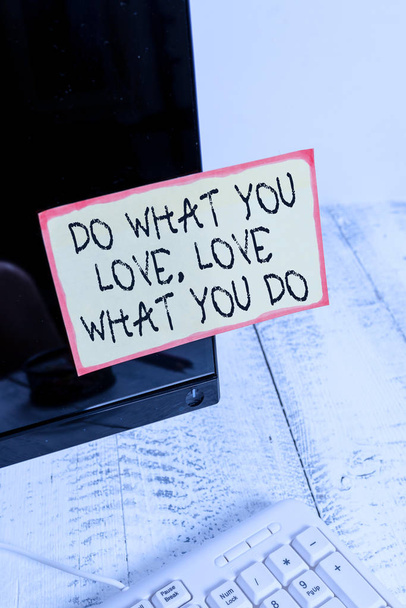 Word writing text Do What You Love Love What You Do. Business concept for Pursue your dreams or passions in life Notation paper taped to black computer monitor screen near white keyboard. - Photo, Image