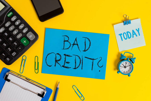 Writing note showing Bad Creditquestion. Business photo showcasing inabilityof a demonstrating to repay a debt on time and in full Clipboard sheet calculator pencil clock smartphone color background. - Photo, Image