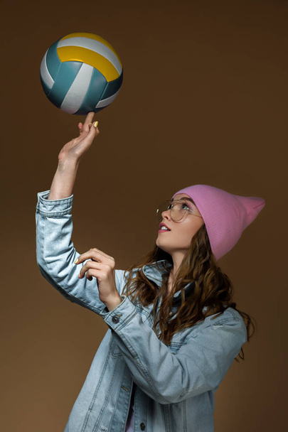 girl in jeans, a pink hat and stylish glasses with a ball - Fotografie, Obrázek
