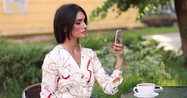 Belarus Minsk 05 26 2019: Woman using mobile phone in outdoor cafe. - Кадри, відео