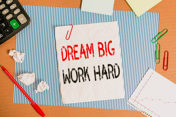 Text sign showing Dream Big Work Hard. Conceptual photo Believe in yourself and follow the dreams and goals Striped paperboard notebook cardboard office study supplies chart paper. - Photo, Image