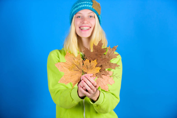 Enjoy autumn season. Autumn skincare tips. Bright moment. Active leisure and rest autumn season. Woman wear knitted hat hold fallen leaves. Skincare and beauty tips. Skincare routine for autumn - Photo, Image
