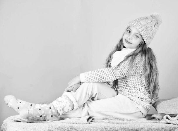 Girl long hair relaxing pink background. Winter fashion for children. Kid smiling fashion model. Winter fashion concept. Kid girl wear cute knitted fashionable hat and comfortable cozy clothes - Foto, imagen