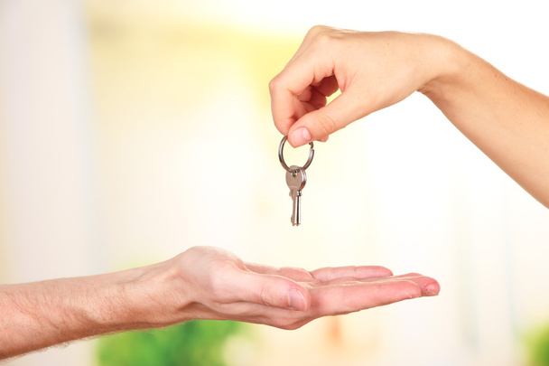 Transfer of house key, on bright background - Photo, Image