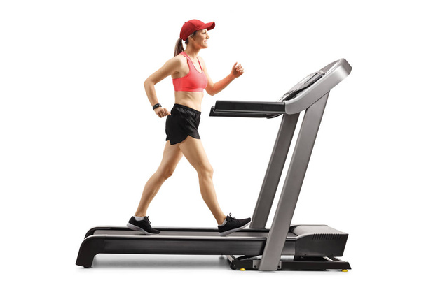 Smiling young female exercising on a treadmill - Foto, Imagen