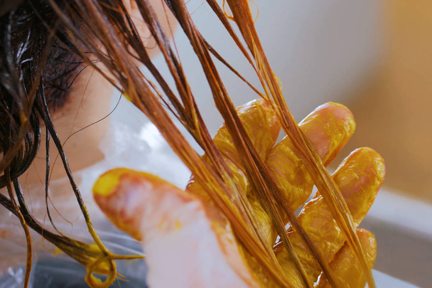 Профессиональный парикмахер раскрашивает волосы женщины-клиента в студии
 - Фото, изображение